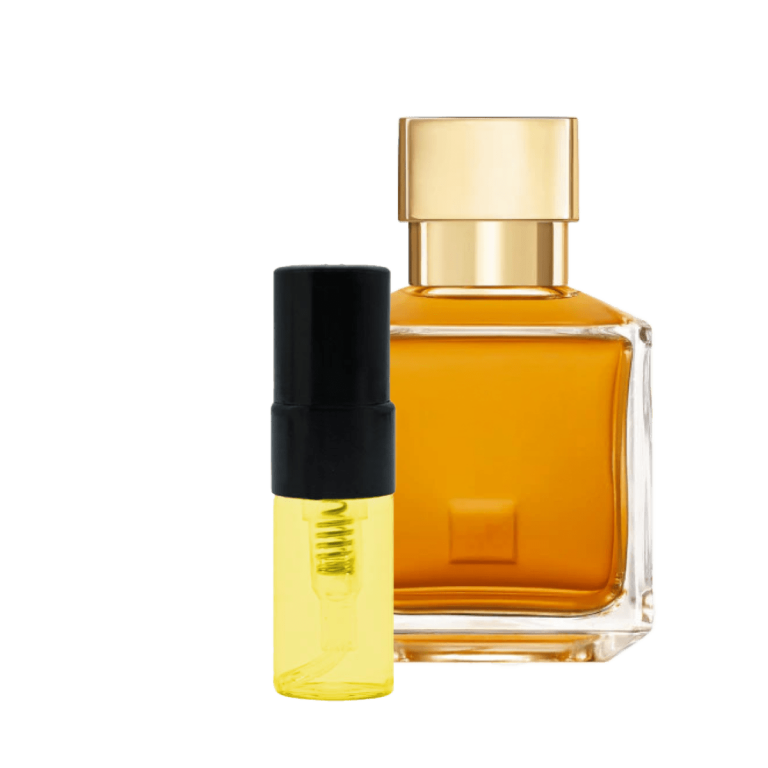 Im Bild befinden sich zwei Fläschchen: Ein großes, eckiges Parfümflakon mit goldfarbenem Verschluss und orangener Flüssigkeit, sowie ein kleines, zylindrisches 2ml Fläschchen mit schwarzem Deckel und gelblichem Inhalt. Beide stehen aufrecht und die Flüssigkeiten wirken klar.